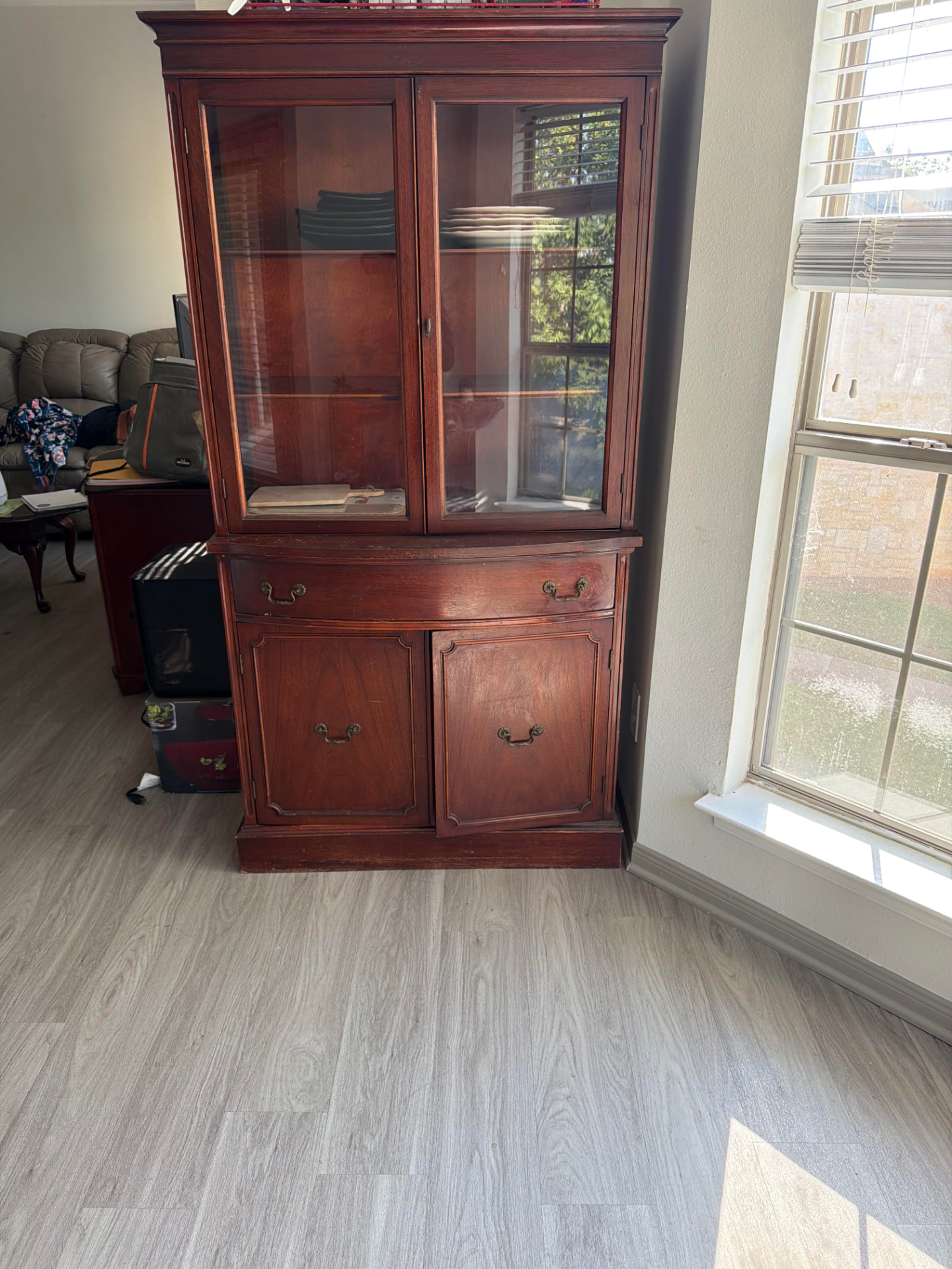 Old china cabinet and stacked furniture before a Granbury home cleanout