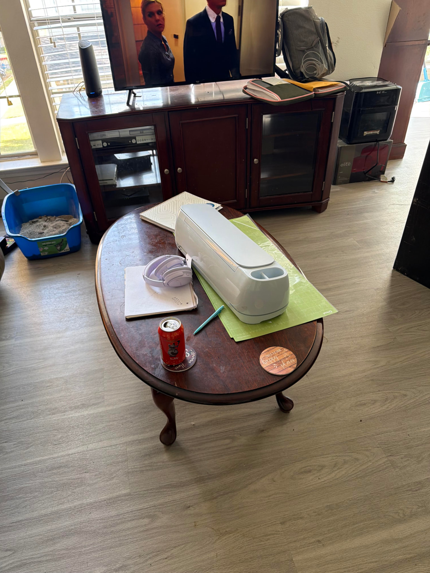 Cluttered coffee table, TV stand, and boxes before a Granbury home cleanout